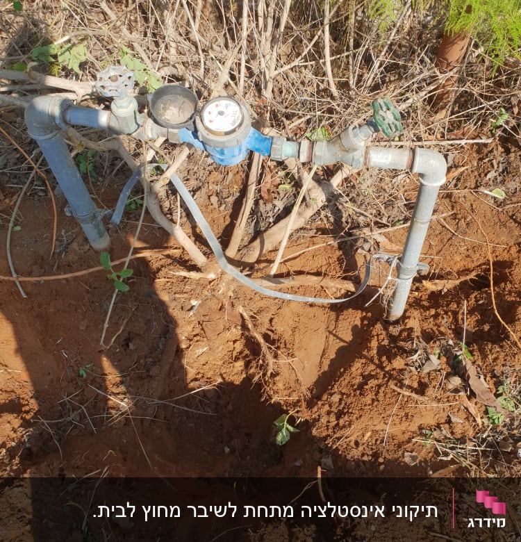 צנרת מים עם מד מים וברזים בשטח פתוח